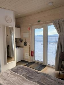 Schlafzimmer mit einem Bett und einer großen Glasschiebetür in der Unterkunft Ugla Gistihús (Ugla Guesthouse) in Hella