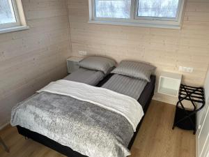 duas camas num pequeno quarto com duas janelas em Ugla Gistihús (Ugla Guesthouse) em Hella