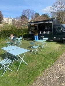 a food truck with tables and chairs in the grass at Emplacement exceptionnel et rare Paris Suresnes longchamp in Suresnes