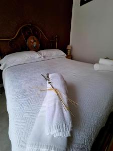 um cobertor branco numa cama com uma cabeceira de madeira em Borgo Scorciarini B&B em Piedimonte dʼAlife