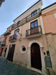 - Edificio con puerta y balcón en Borgo Scorciarini B&B en Piedimonte dʼAlife