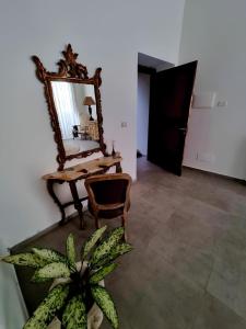 um espelho sobre uma mesa com uma cadeira e uma planta em Borgo Scorciarini B&B em Piedimonte dʼAlife