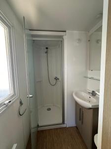 a bathroom with a shower and a sink at Mobilhome cosy tout confort 6-8 personnes in Valras-Plage