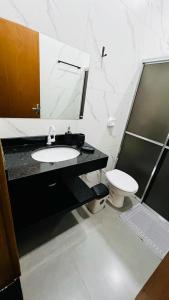 a bathroom with a sink and a toilet at Casa da Estadia Tranquila. in Dourados +38 photos