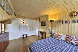 a bedroom with a bed and a desk in a room at Attic Chesa Charots - Celerina in Celerina