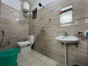 a bathroom with a sink and a toilet at ValleyView Homestay in Mukteswar