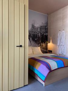 1 dormitorio con 1 cama y una pintura en la pared en Stadslogement Het Keerpunt Dokkum, en Dokkum