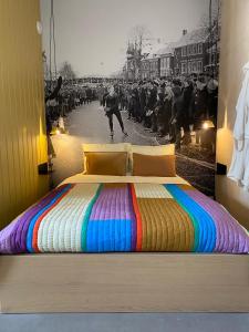 a bedroom with a colorful bed with a crowd of people at Stadslogement Het Keerpunt Dokkum in Dokkum