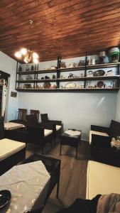 a restaurant with couches and tables and shelves with dishes at Olympiades Rooms Litóchoro in Litochoro