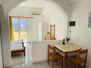 PROFILIO Apartments & Studios في Exopoli: مطبخ وغرفة طعام مع طاولة وكراسي