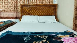 a bedroom with a bed with a wooden headboard at New Hotel Labbaik 3 in Dhaka