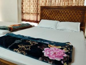 a bed with a blanket on top of it at New Hotel Labbaik 3 in Dhaka