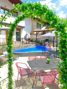 eine Terrasse mit einem Tisch, Stühlen und einem Pool in der Unterkunft Къща за гости Casa Per Te in Marchevo