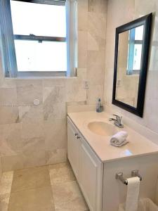 een badkamer met een wastafel en een spiegel bij Oceanview 2 bdrm Beachfront Condo Hollywood FL in Hollywood