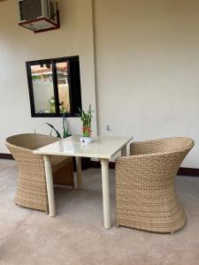 une table et des chaises blanches avec une plante. dans l'établissement Mingche Apartment, à Panglao