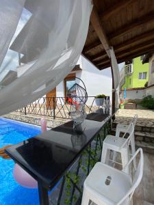 einen Tisch und Stühle auf einer Terrasse mit Pool in der Unterkunft Къща за гости Casa Per Te in Marchevo