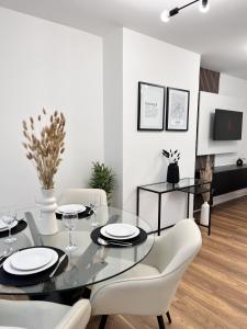 uma sala de jantar com uma mesa de vidro e cadeiras brancas em Modern 2 Bedroom Home in Edinburgh Free Parking em Edimburgo