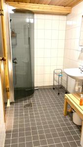uma casa de banho com um chuveiro e um lavatório. em Arctica em Saariselka