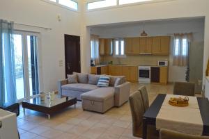 a living room with a couch and a table at SunShine House in Ermoupoli