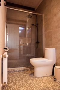 a bathroom with a toilet and a glass shower at Espectacular Casa Palafito frente al mar in Pichilemu +30 photos