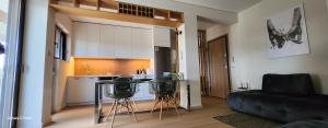 uma sala de estar com um sofá e uma cozinha em Zouberi Τwins Luxury Appartments(South) em Nea Makri