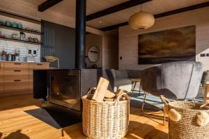 a living room with a fireplace and two baskets at Espectacular Casa Palafito frente al mar in Pichilemu