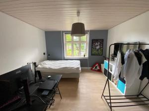 a room with a bed and a desk with a computer at Wonderful house & garden in Tommerup