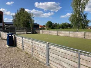 a fence with a tennis court in a field at Wonderful house & garden in Tommerup +31 photos