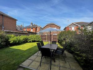 a table and chairs with an umbrella in a yard at Briar Bank in Shanklin