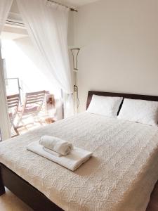 ein weißes Bett mit einem Handtuch darüber in der Unterkunft Dianos apartamentai in Palanga