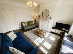a living room with a blue couch and a mirror at Briar Bank in Shanklin +67 photos