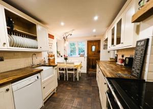 een keuken met witte kasten en een tafel. bij 1 Apse Castle Cottage - Pet Friendly in Shanklin