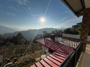 a balcony of a house with a view of the mountains at ValleyView Homestay in Mukteswar