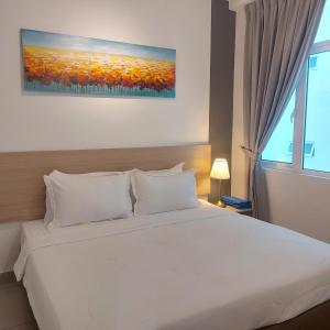 sypialnia z dużym białym łóżkiem i oknem w obiekcie TWIN GALAXY JB Homestay by SUMMER w mieście Johor Bahru