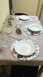 a table with plates and glasses on top of it at Casa praiana - agradável e confortável ambiente com ar-condicionado in Parnaíba