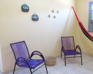 two purple chairs sitting in a room with a wall at Casa praiana - agradável e confortável ambiente com ar-condicionado in Parnaíba
