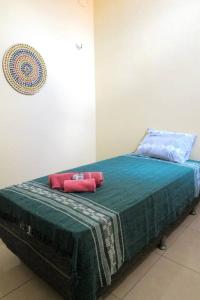 ein Bett mit zwei roten Kissen darüber in der Unterkunft Casa praiana - agradável e confortável ambiente com ar-condicionado in Parnaíba