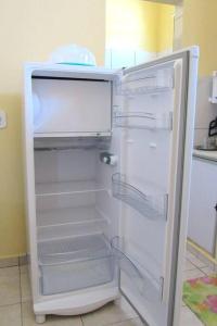 an empty refrigerator with its door open in a kitchen at Casa praiana - agradável e confortável ambiente com ar-condicionado in Parnaíba