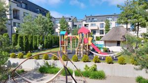 a playground in a park with a slide at Neringos apartamentai in Palanga