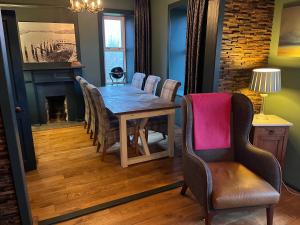a dining room with a table and chairs and a fireplace at Kilda House in Leverburgh
