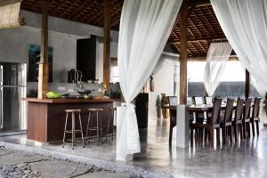 a kitchen with a table and chairs in a room at Surflodge Limasan Bali in Kerobokan