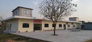 a building with a tree in front of it at Shivansh Palace HomeStay & Marriage Garden in Khajurāho