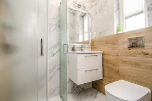 a bathroom with a toilet and a sink and a shower at Willa Anavill in Mielno