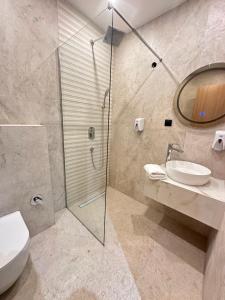 a bathroom with a shower and a toilet and a sink at Hotel Suljovic in Sarajevo