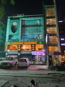 ein Gebäude mit nachts vor ihm geparkt in der Unterkunft HOTEL AKASH in Ahmedabad