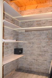 a room with a brick wall with shelves at Duplex/ Appart hotel in El Biar
