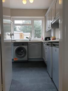 a kitchen with a washing machine and a window at Spencefield House in Leicester
