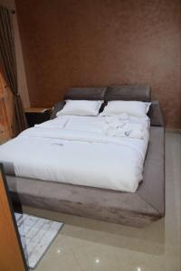 a bed with white sheets and pillows on it at Duplex/ Appart hotel in El Biar
