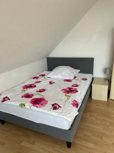 ein Bett mit roten Rosen in einem Schlafzimmer in der Unterkunft Moderne 3 Zimmer Wohnung in Heiligenhaus in Heiligenhaus
