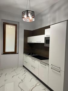 eine Küche mit weißen Schränken und einem Kronleuchter in der Unterkunft CADIFRA Suite Napoli Toledo in Neapel